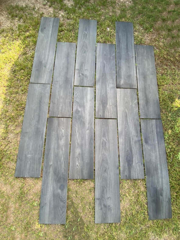 Anthracite wood effect porcelain paving planks laid in a garden landscape