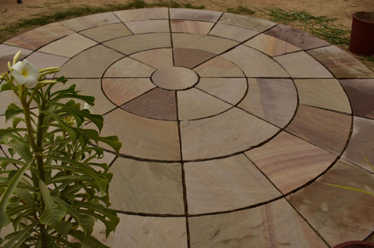 Rippon Buff sandstone circular stone setts, warm multi tone paving design.