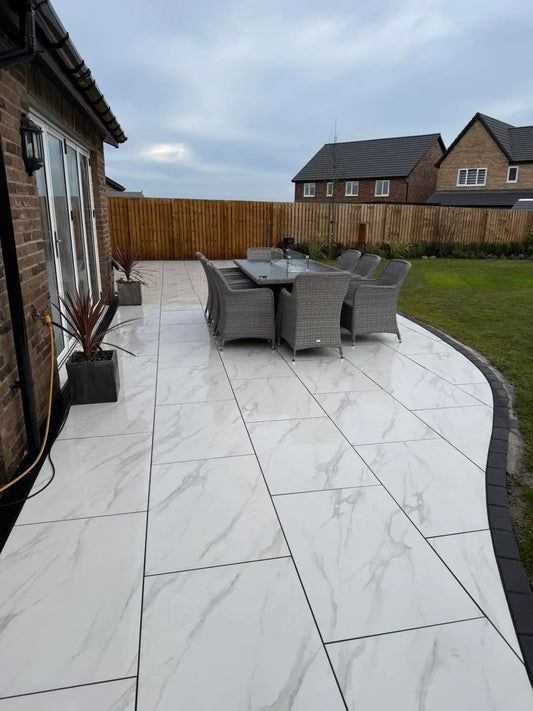 Statuario marble effect white porcelain slabs layout in a garden setting
