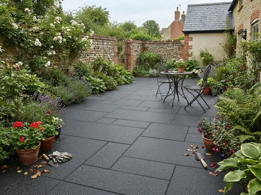Black granite paving slabs used for a garden patio surrounded by lush green plants.
