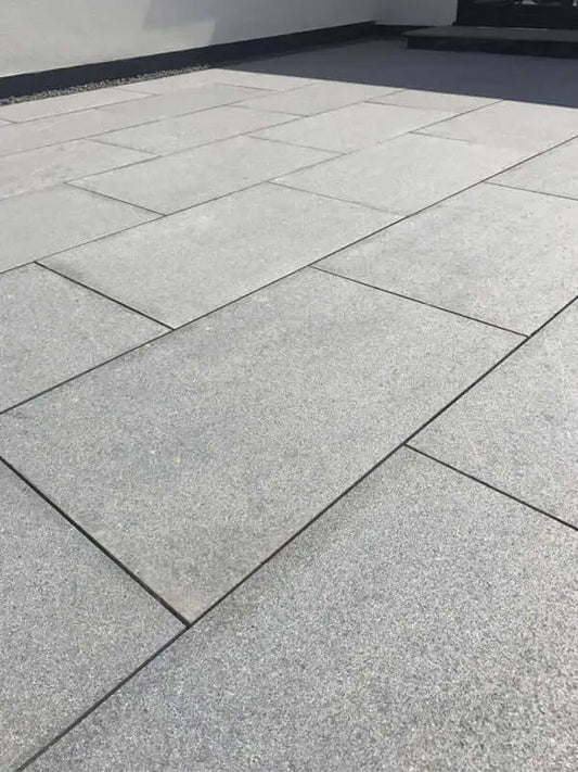 Grey granite effect 900x600 mm porcelain paving slabs in a garden patio layout