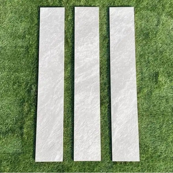Three Kandla grey porcelain garden edging slabs (90x20 cm) set neatly on green lawn grass.