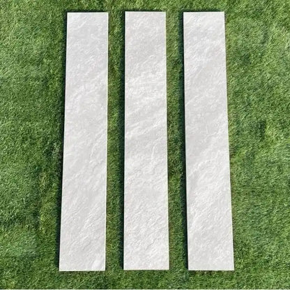 Three Kandla grey porcelain garden edging slabs (90x20 cm) set neatly on green lawn grass.