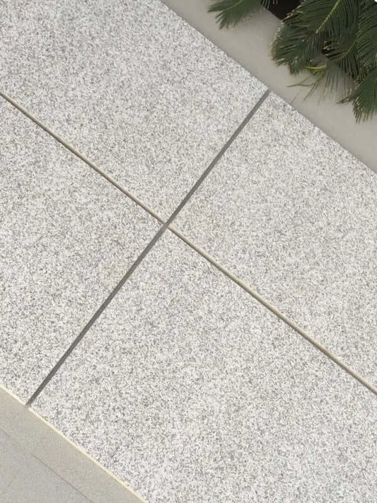 Silver grey granite effect porcelain paving slabs laid on an outdoor patio
